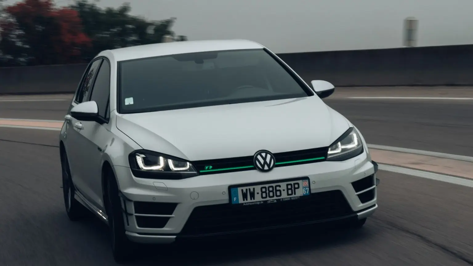 a white volkswagen car driving down a road